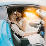 a couple kissing in a wedding dress and tuxedo, seated in the fronts seat of a vehicle