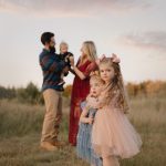 a family with a father, mother and 3 daughters in a field