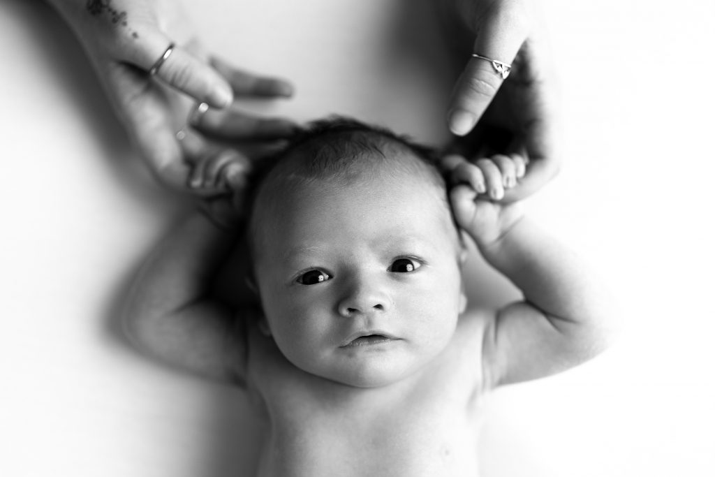 newborn black and white expressions eyes open holding mom and dad's hands concord new hampshire studio