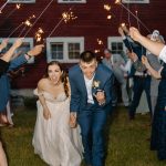 wedding photography bishop farms weddings and events new hampshire bride and groom walking through sparkler sendoff red barn