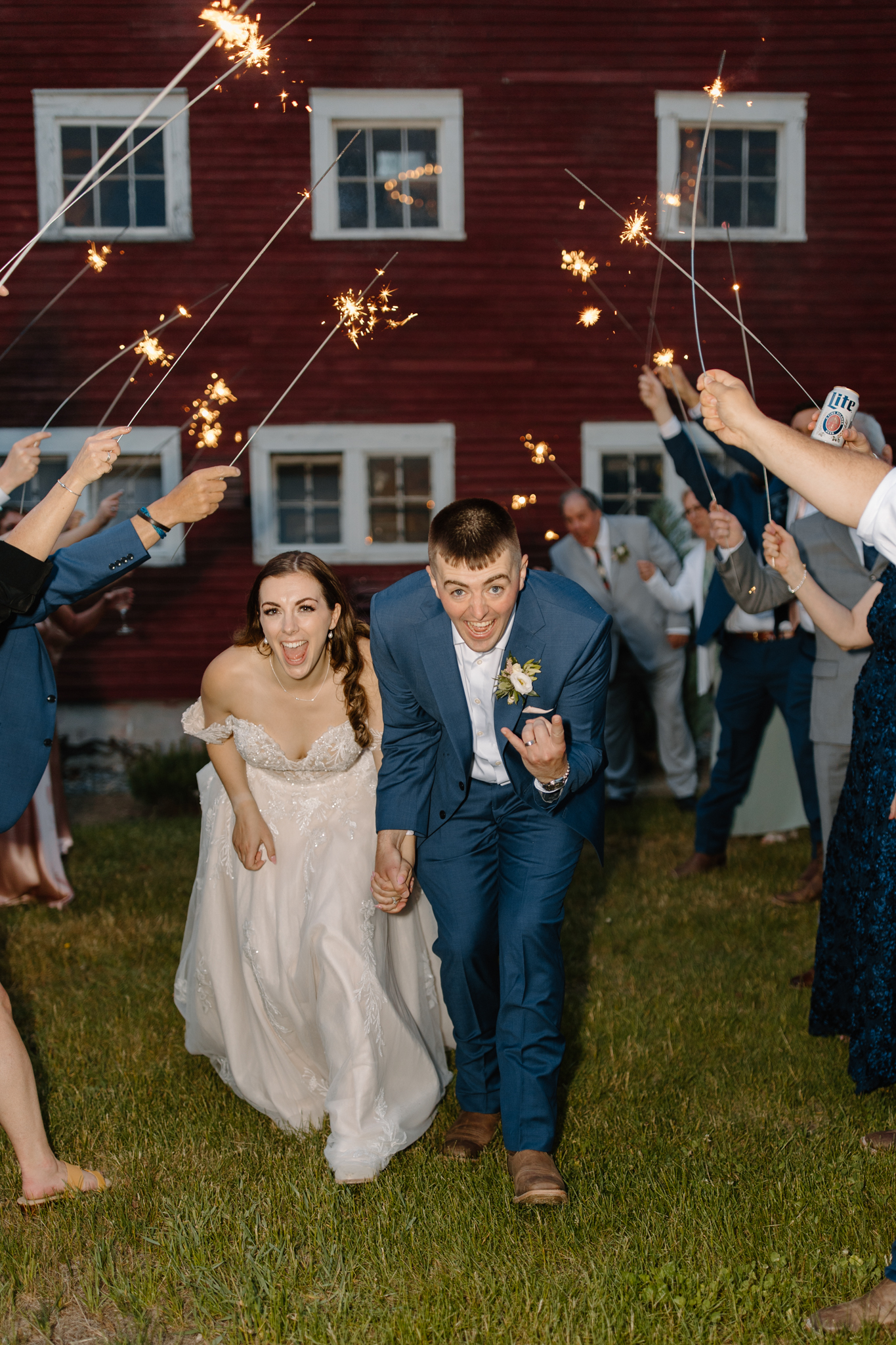 wedding photography bishop farms weddings and events new hampshire bride and groom walking through sparkler sendoff red barn
