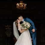 wedding photography bishop farm weddings and events new hampshire wedding venue red barn white curtain chandelier bride and groom kissing