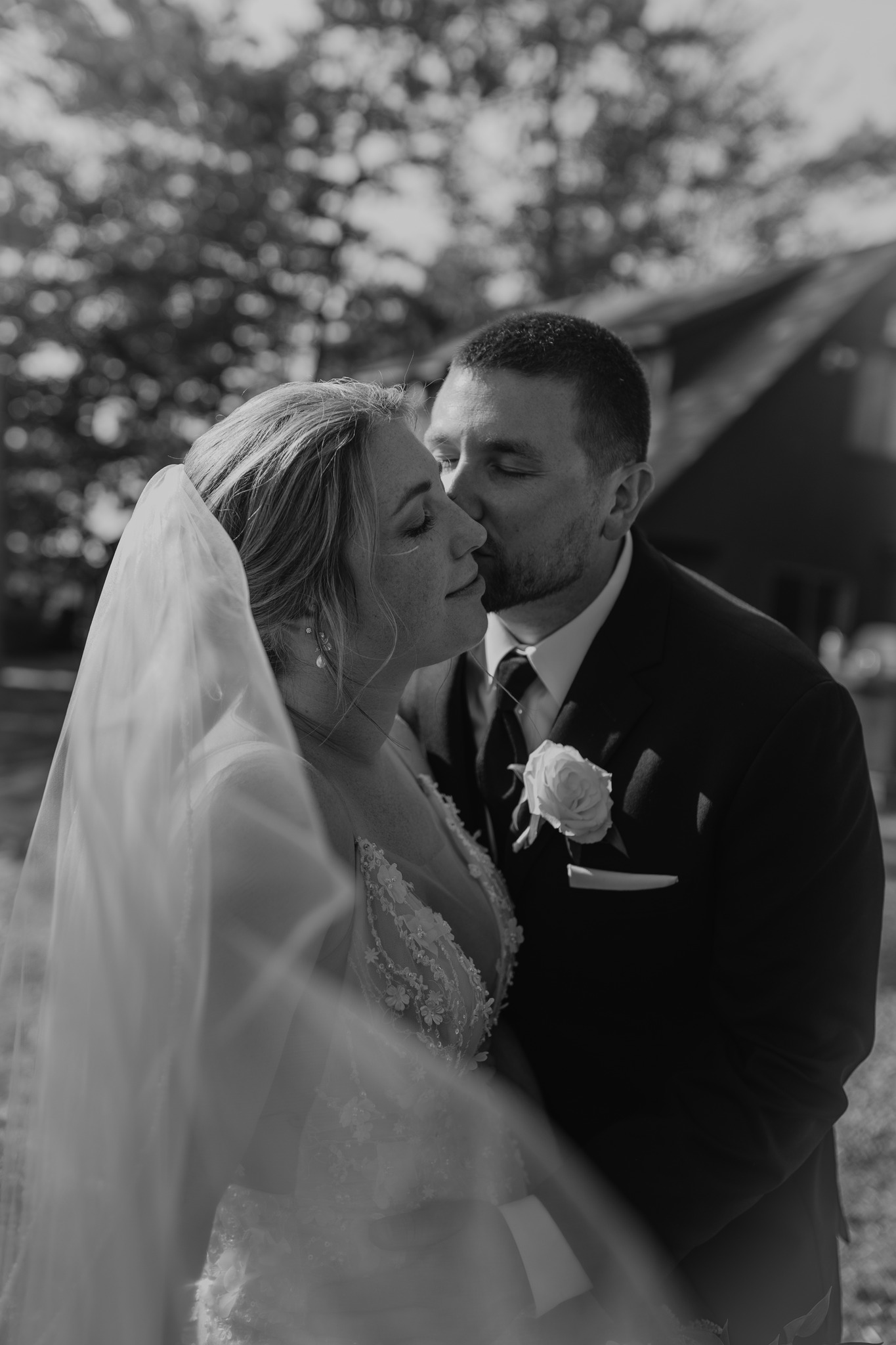 wedding photography black and white groom kissing bride with veil new hampshire