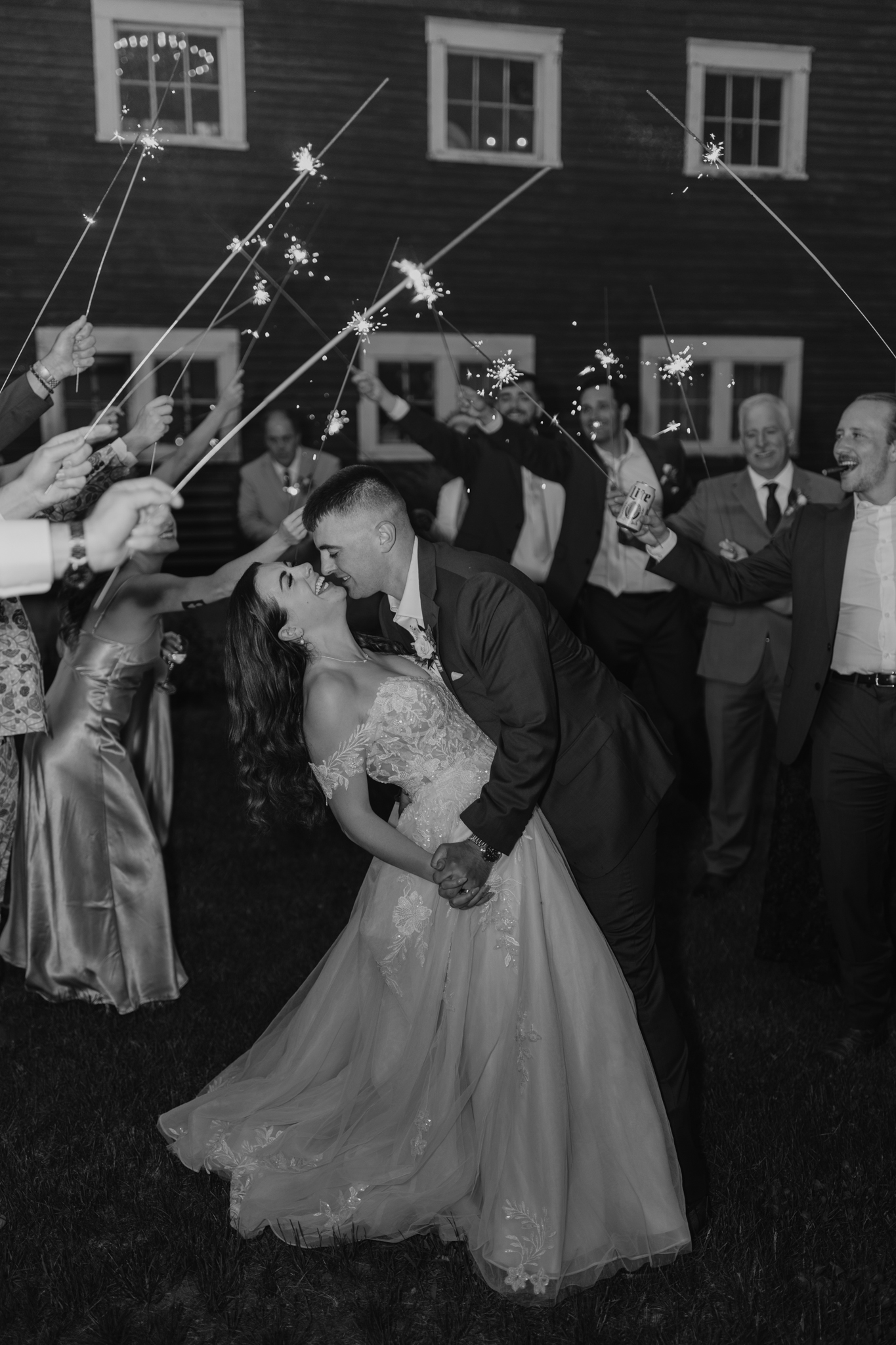 wedding photography bishop farms weddings and events new hampshire bride and groom walking through sparkler sendoff red barn black and white
