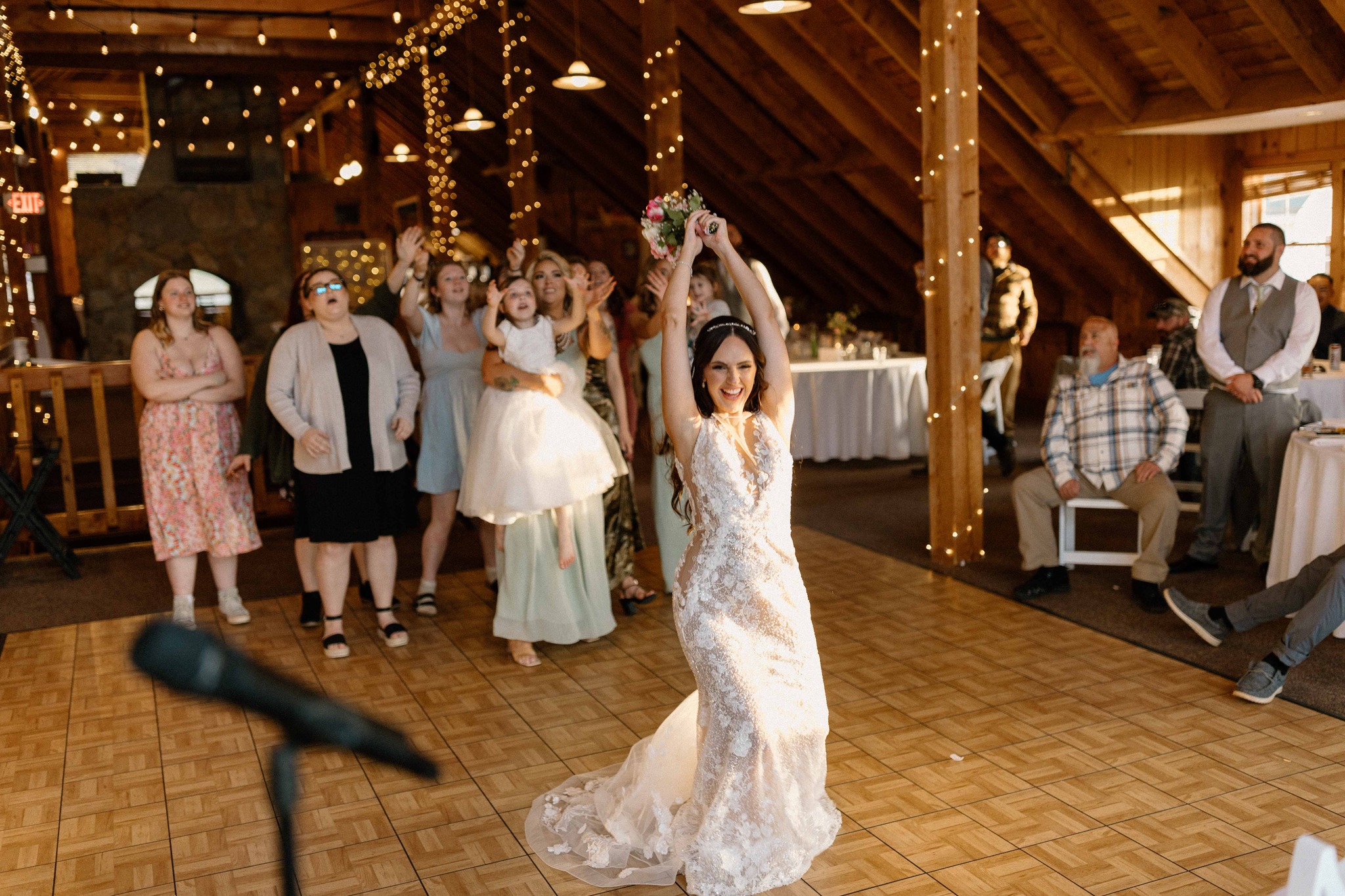 wedding photography pike's peek wedding venue new hampshire bride tossing bouquet to women at wedding reception