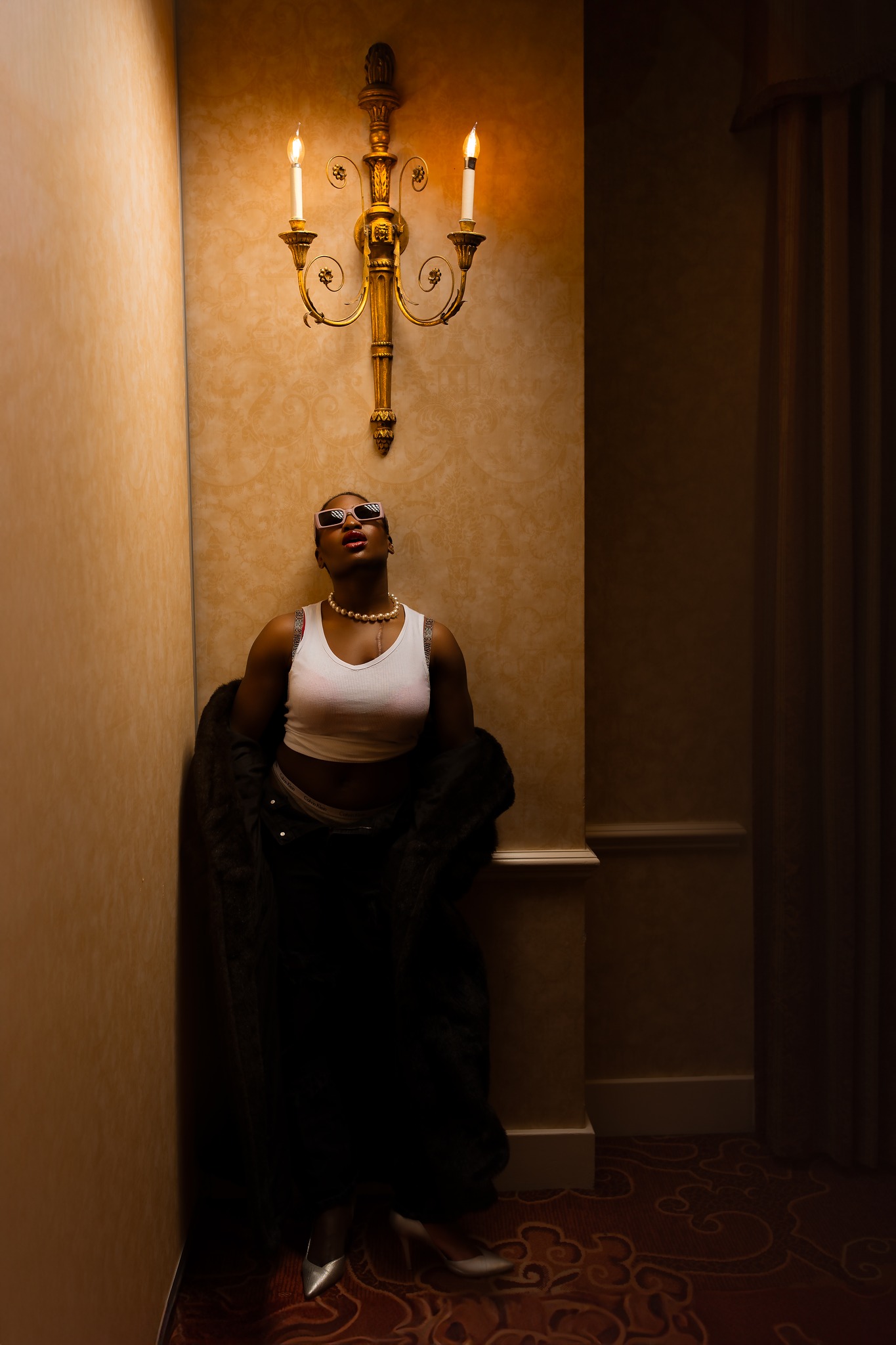 portrait photography woman standing against wallpaper chandelier hotel studio lights concord new hampshire