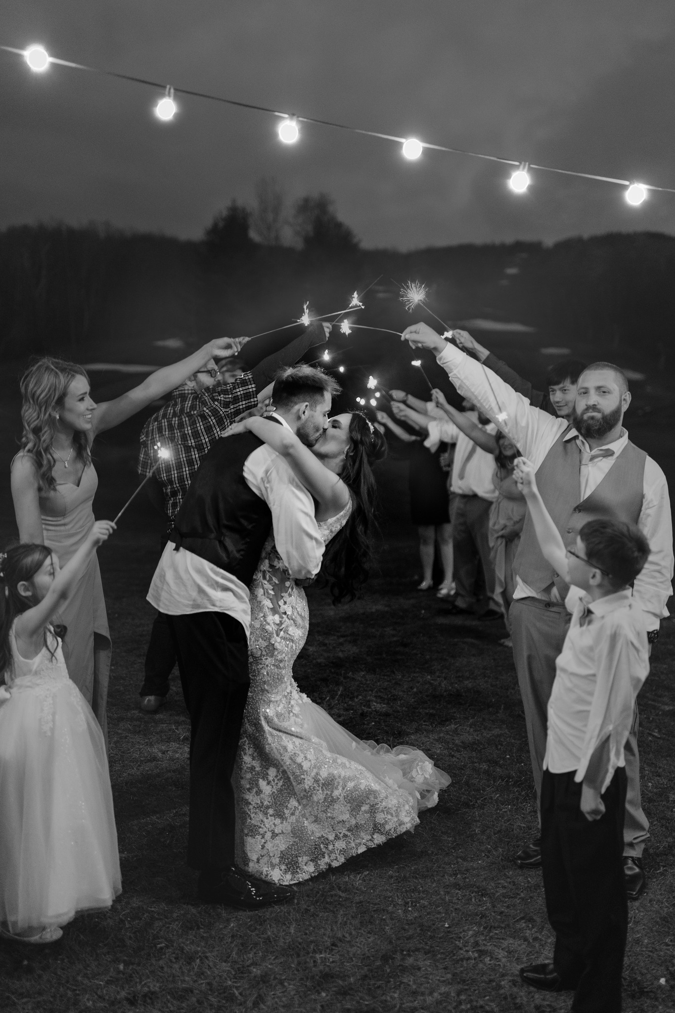 wedding photography bride and groom kissing under sparkler sendoff pikes peek new hampshire wedding venue black and white