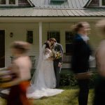 wedding photography white house bride and groom kissing bridal party walking in a blur past them locke falls farm new hampshire