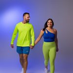 workout fitness photography husband and wife holding hands branding portraits green and blue outfits holding hands walking concord new hampshire studio