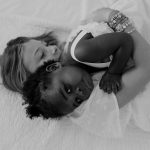 sisters family portrait siblings black and white hallway concord new hampshire snuggling on bed