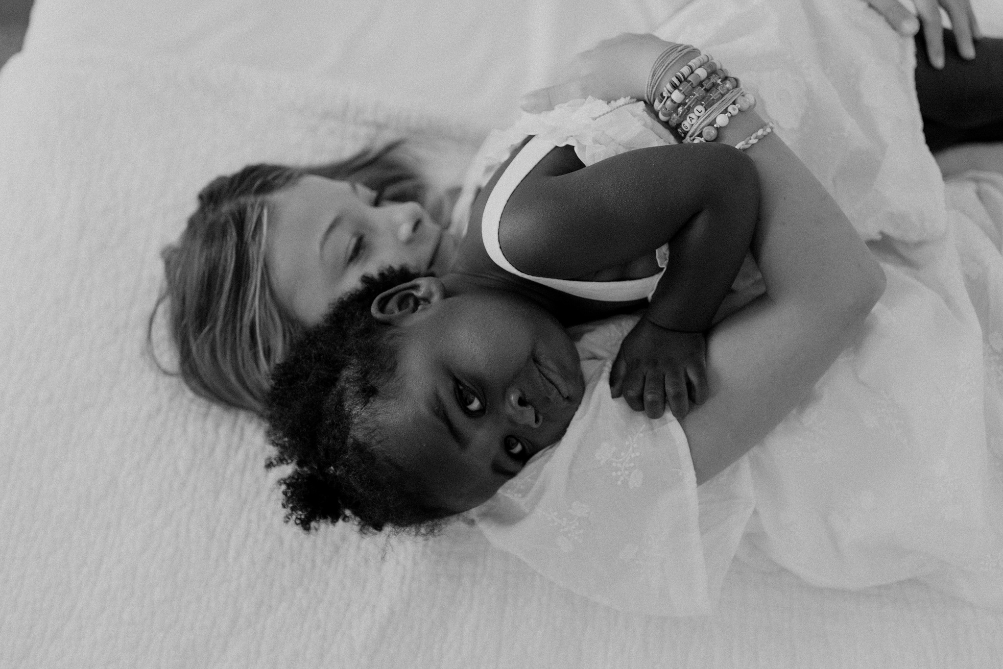 sisters family portrait siblings black and white hallway concord new hampshire snuggling on bed