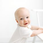 childhood milestone photography portrait white backdrop natural light white shirt bench standing concord new hampshire studio