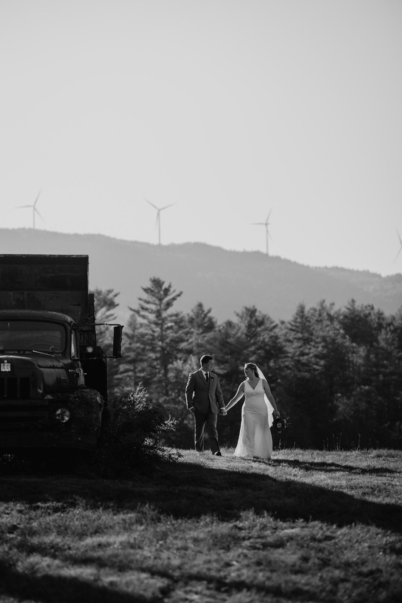 wedding photography black and white bride and groom windmills holding hands old truck yeaton family farm new hampshire
