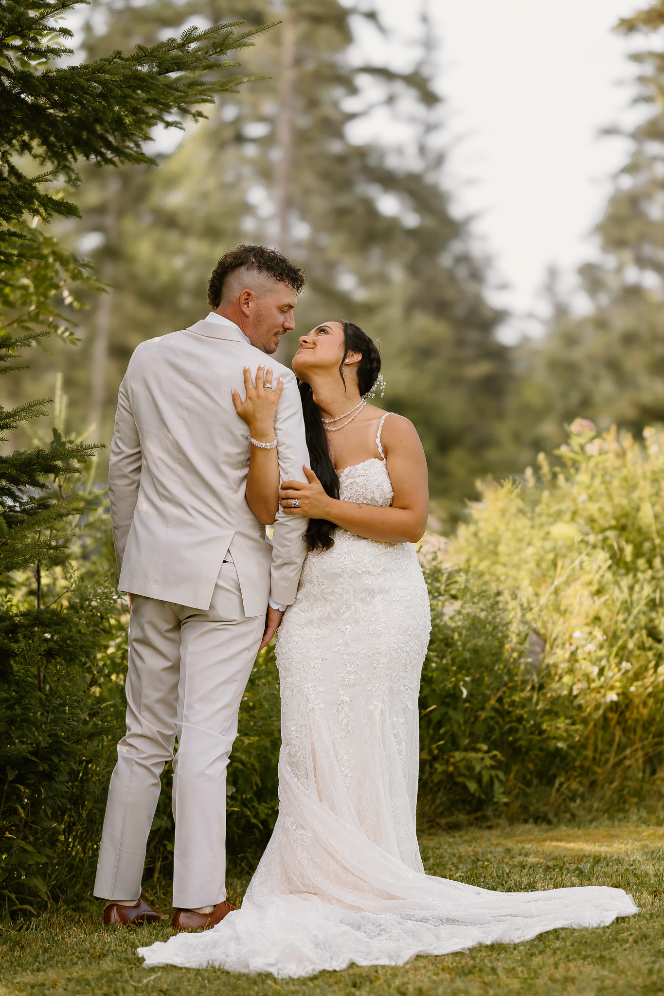 wedding portrait where bride and groom are holding each other, tan suit, outdoors, woods, nh