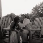 wedding portrait where husband and wife bride and groom are sitting on railing of porch, sunset, golden hour, nh sitting in chairs
