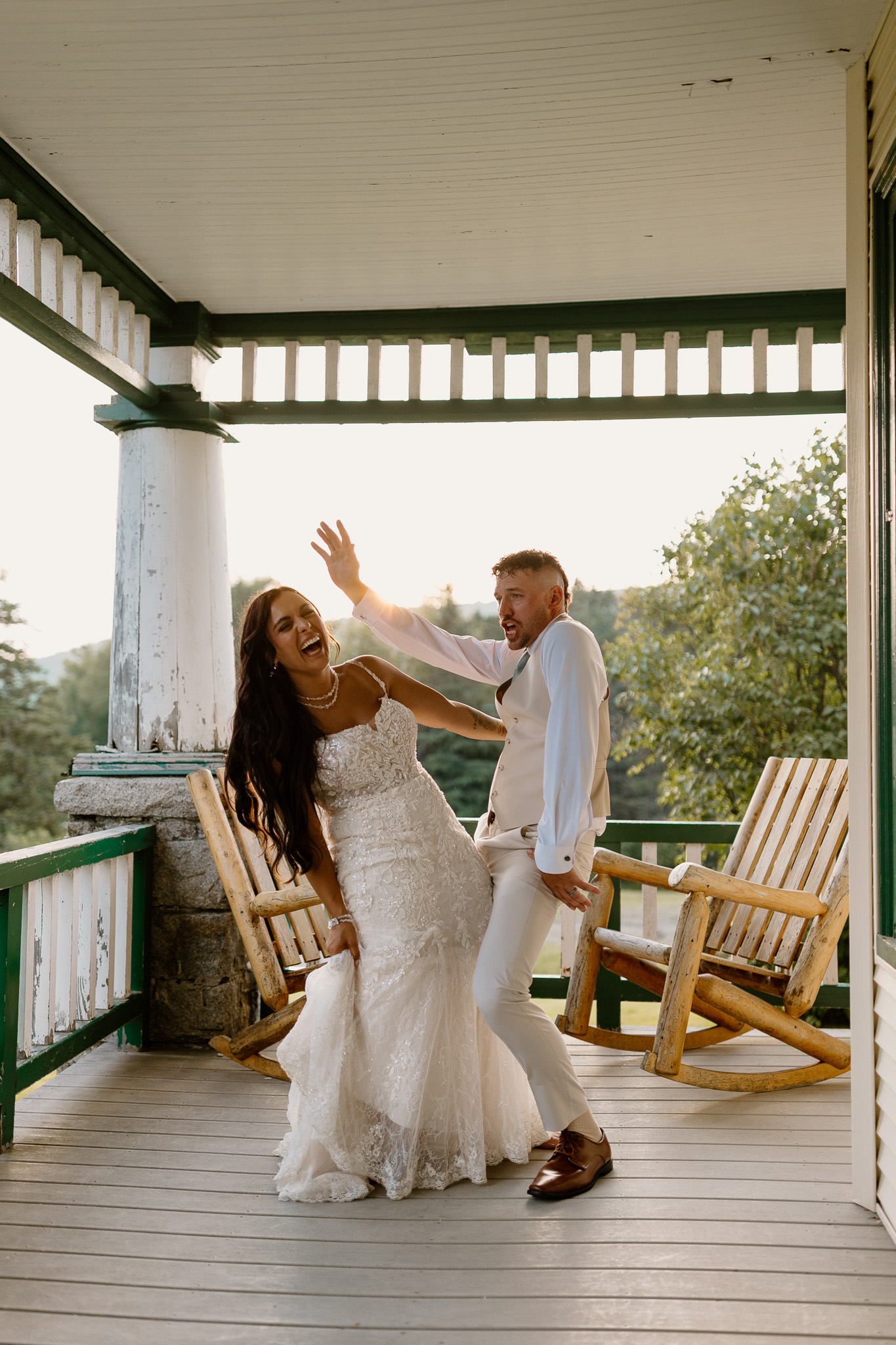 wedding portrait where husband and wife bride and groom are sitting on railing of porch, sunset, golden hour, nh dancing