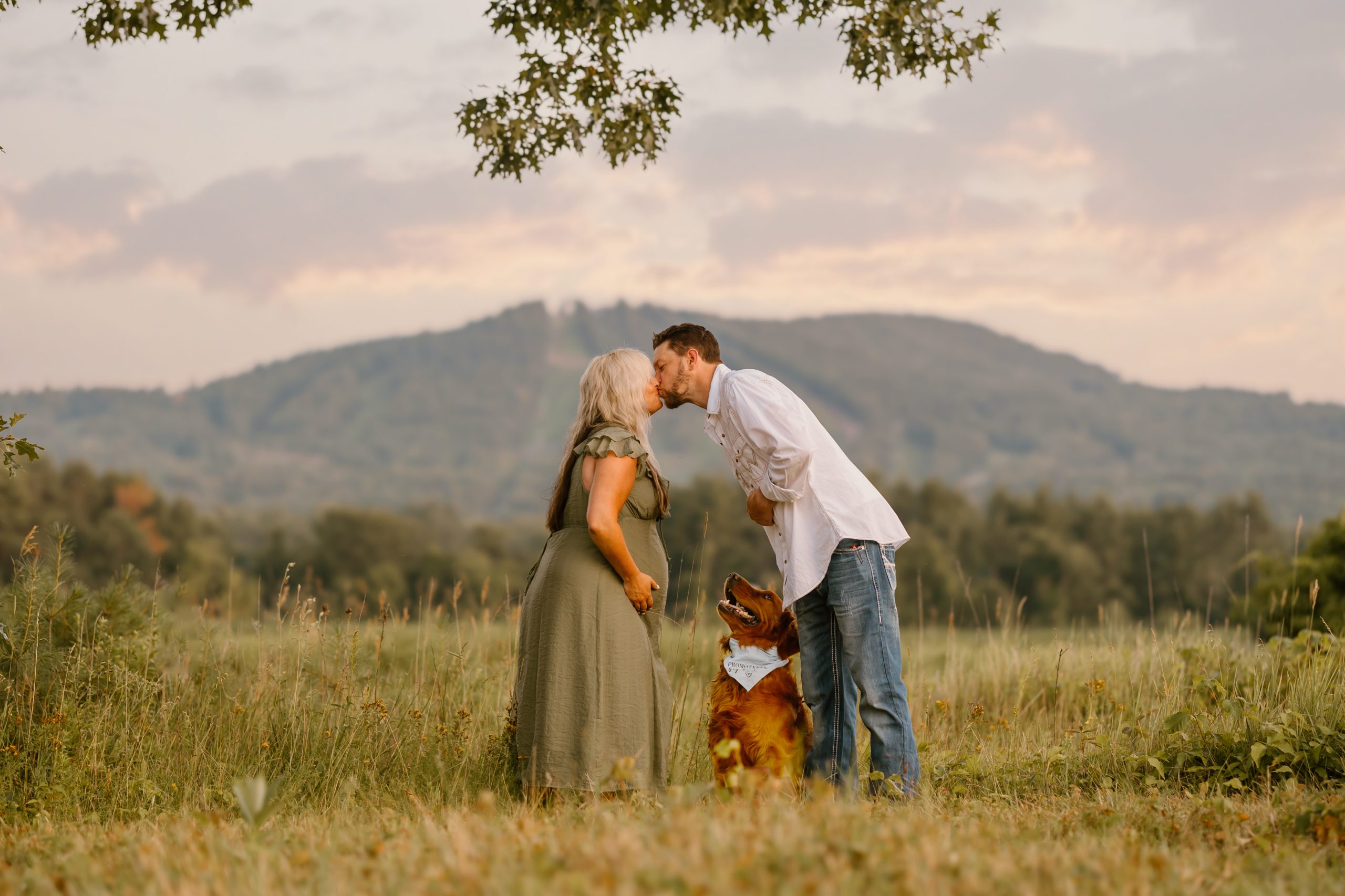 Maternity portrait with couple and golden retriever dog with mountains in background, NH