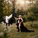 maternity portrait where mom is wearing a black gown and touching her horse who is black and white, sunset, golden hour, NH