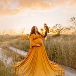 Maternity portrait where mom is holding an owl in her hands, yellow dress, NH