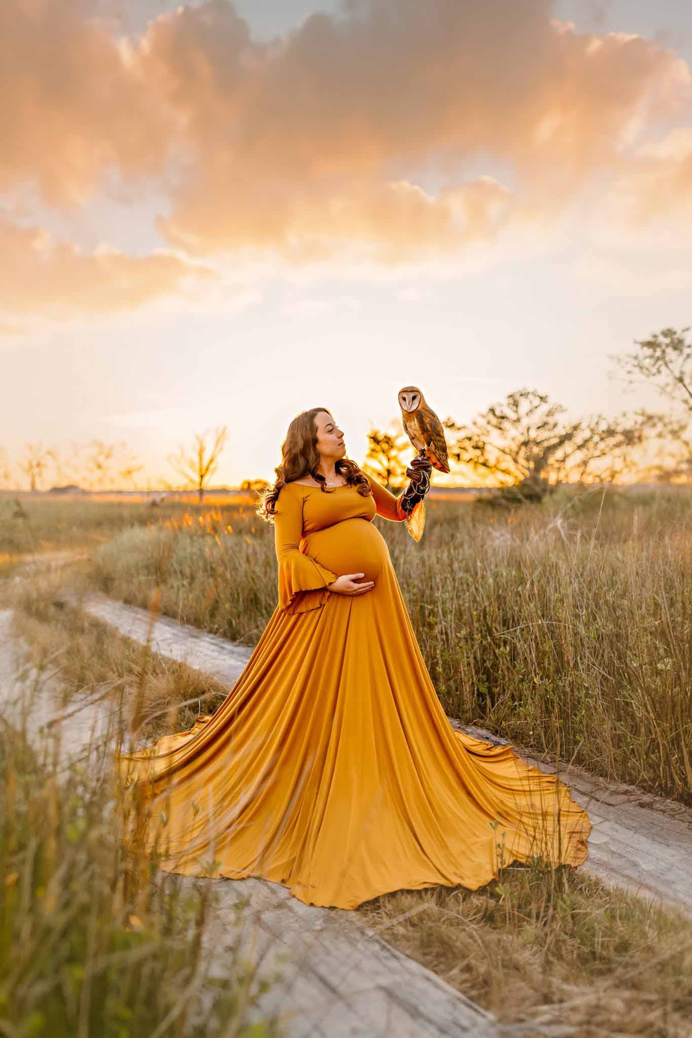 Maternity portrait where mom is holding an owl in her hands, yellow dress, NH