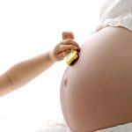 pregnant belly with child driving toy car over the bump NH
