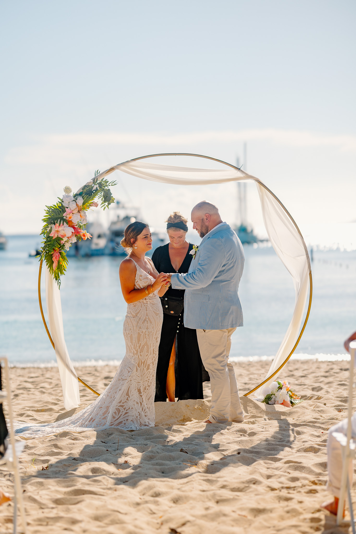 Bride and groom exchange vows during a beach wedding ceremony on Water Island, St. Thomas, USVI, surrounded by tropical ocean views.
