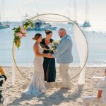 Bride and groom exchange vows during a beach wedding ceremony on Water Island, St. Thomas, USVI, surrounded by tropical ocean views.