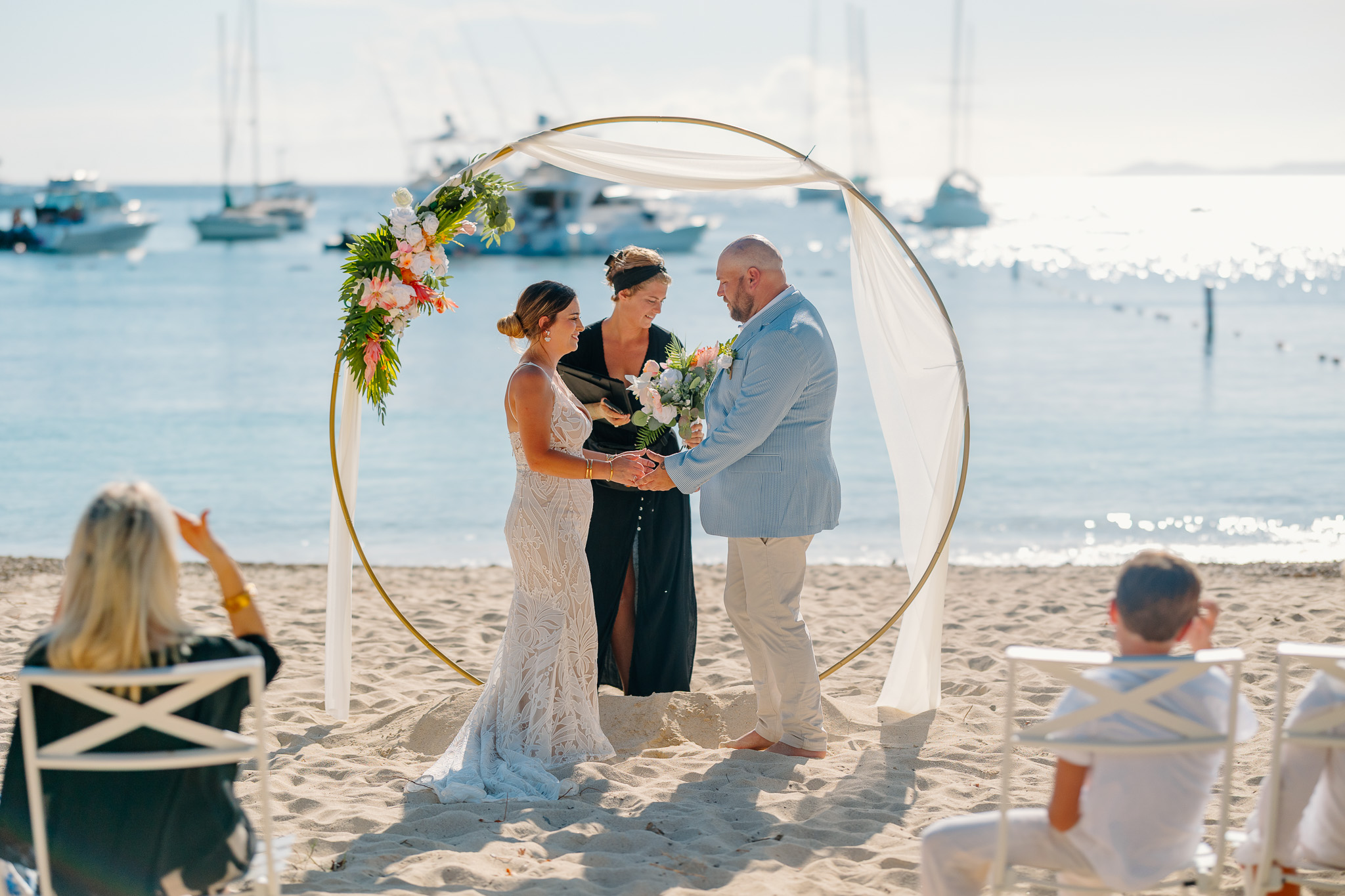 Bride and groom exchange vows during a beach wedding ceremony on Water Island, St. Thomas, USVI, surrounded by tropical ocean views.