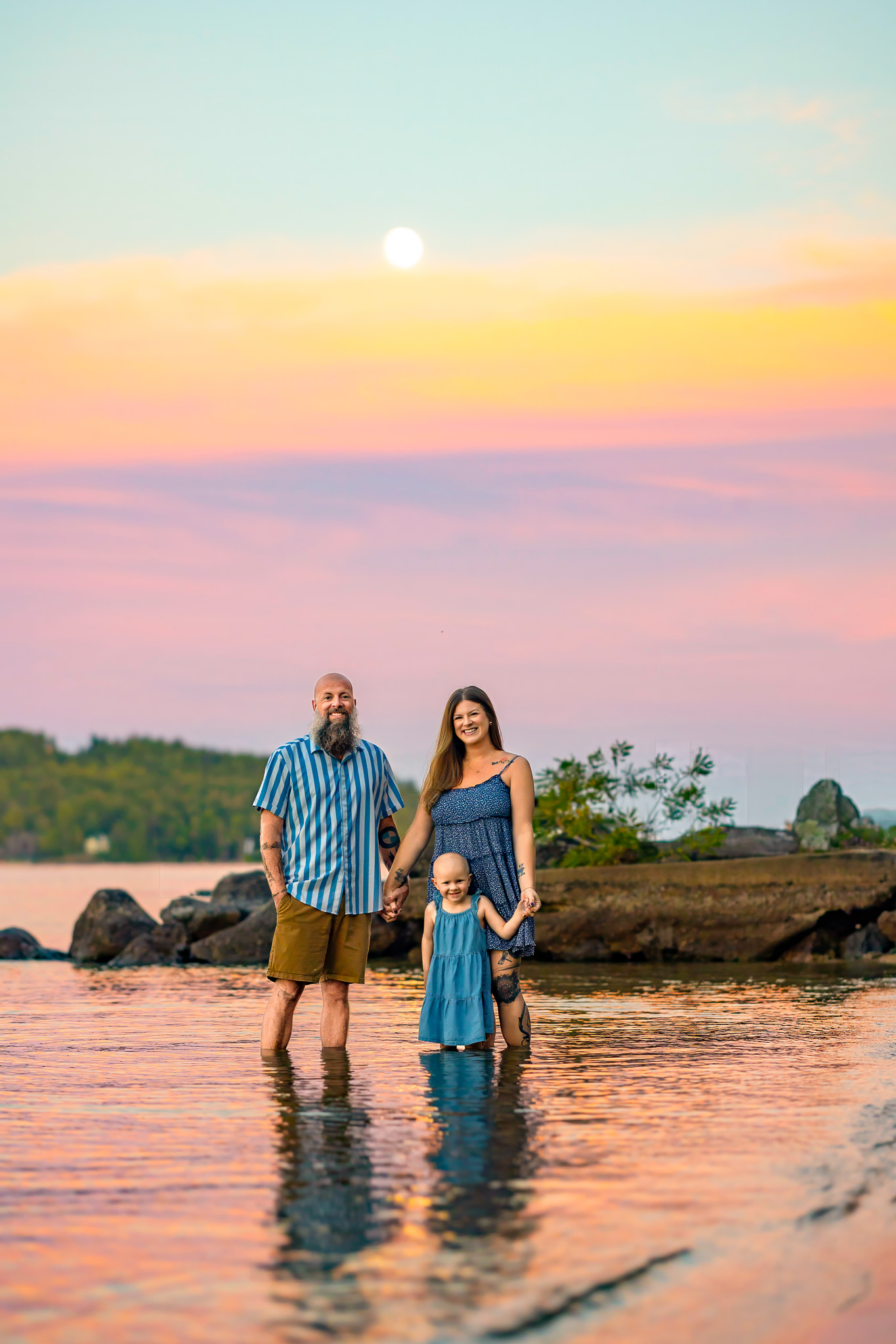 family splashing in the water during sunset at lake winnipesaukee