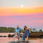 family splashing in the water during sunset at lake winnipesaukee