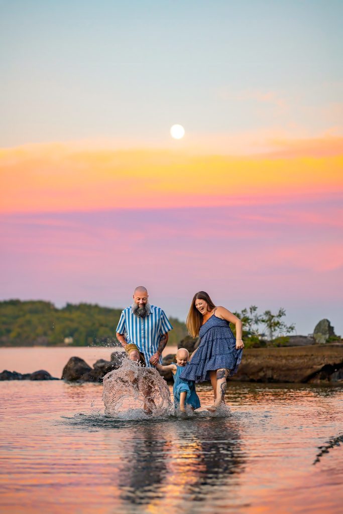 family splashing in the water during sunset at lake winnipesaukee