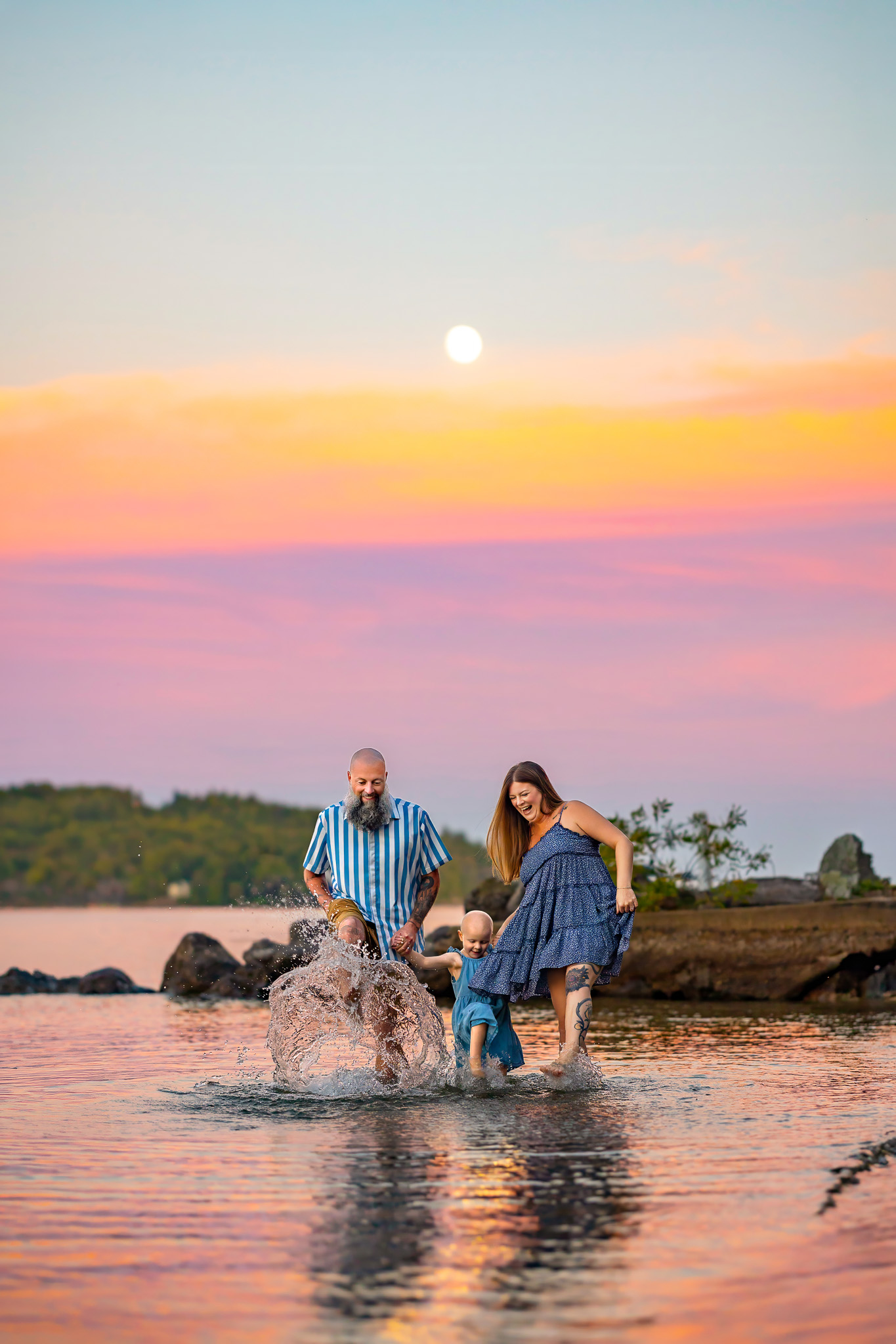 family splashing in the water during sunset at lake winnipesaukee